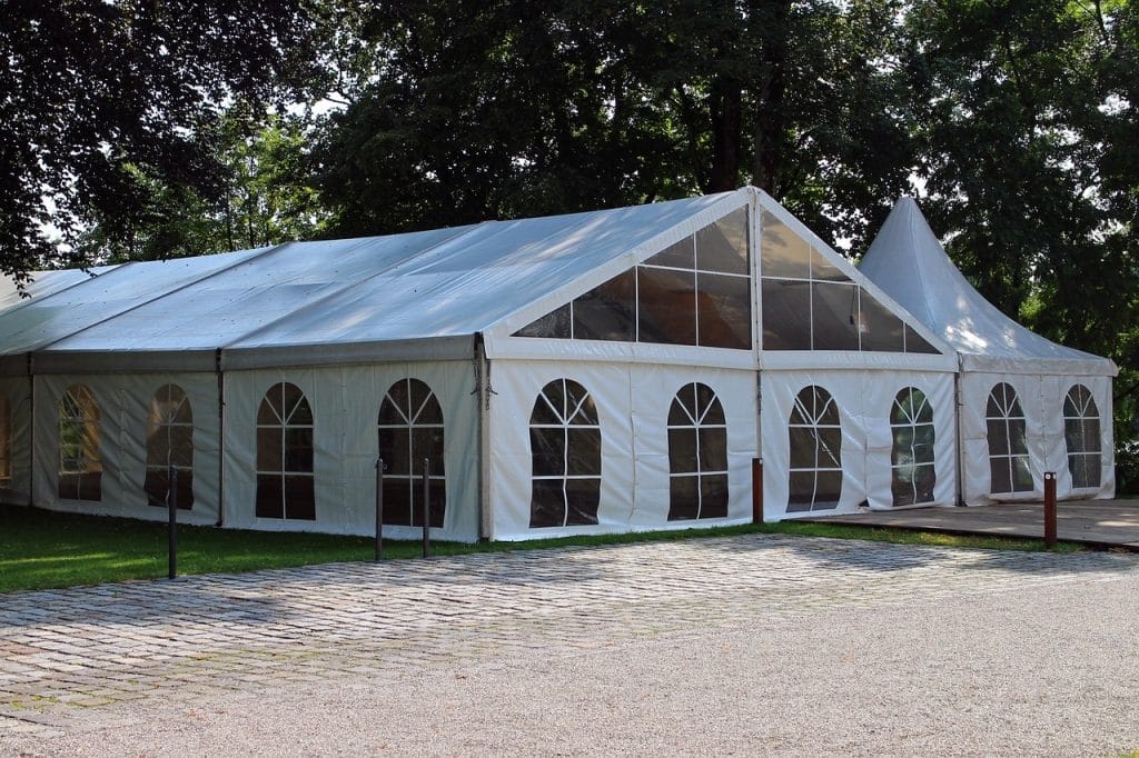 Hvidt festtelt med buede vinduer i en park